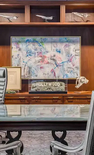 Executive office at Robertson Investment Management in Houston with wood paneling, diplomas, and boardroom table